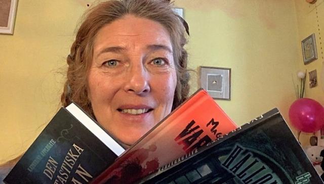 Läsambassadör Henrika Andersson med en bunt böcker i handen