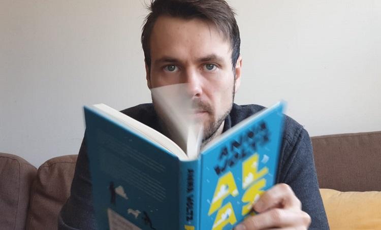 Textförfattaren Mikael Gros sitter och läser en bok.